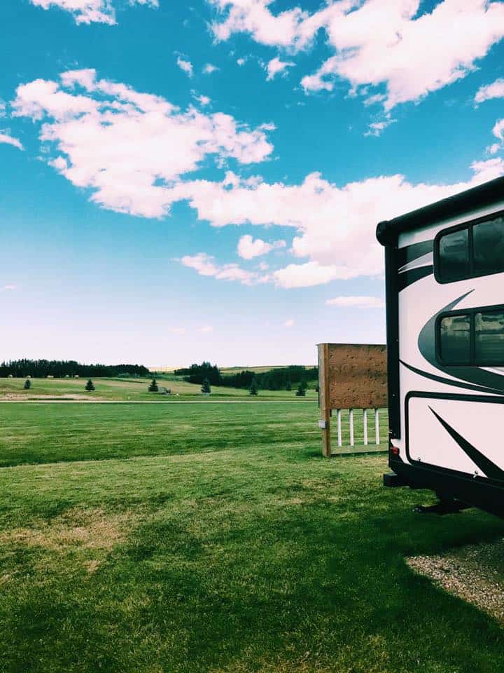 RV parked in wide open meadow at RV resort