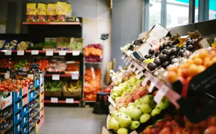 Grocery store aisle filled with fresh fruit and vegetables.