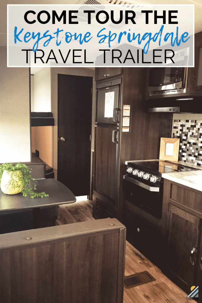 Kitchen stove inside RV with text 'Tour the Keystone Springdale 260BH travel trailer'