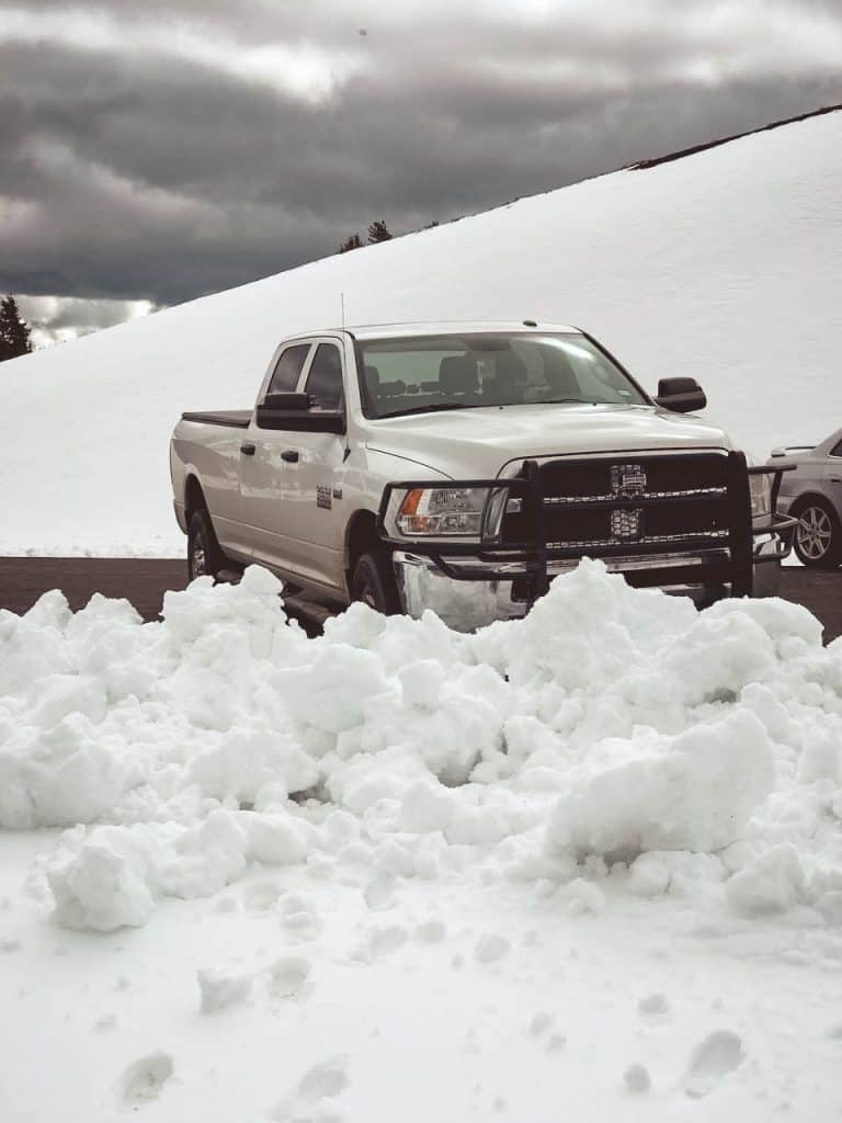Truck parked near pile of snow during winter RV trip