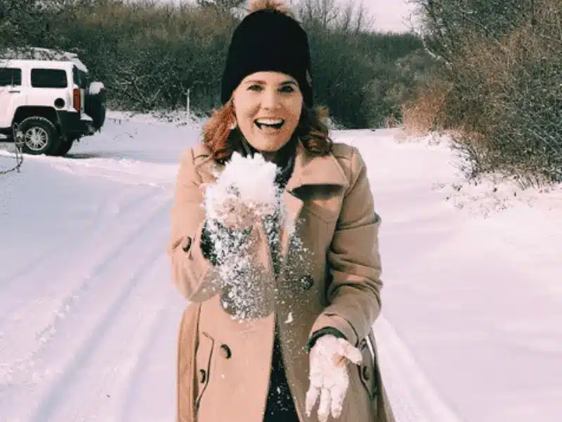 Julie Bonner outside in snow while traveling by RV during winter.