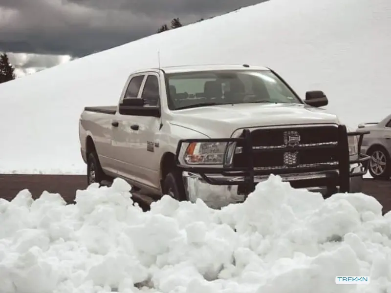 White truck parked near snow bank during winter.