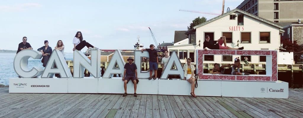 Friends posting for picture on sign with word 'Canada'
