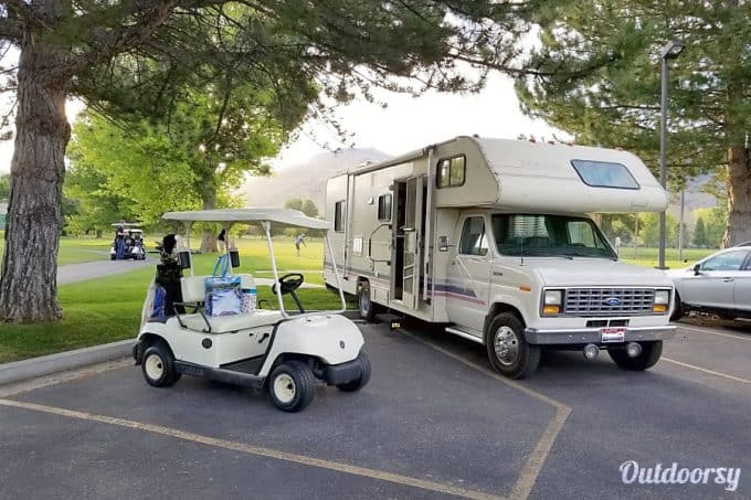 Golf car parked near a Large RV rental available near Yellowstone National Park