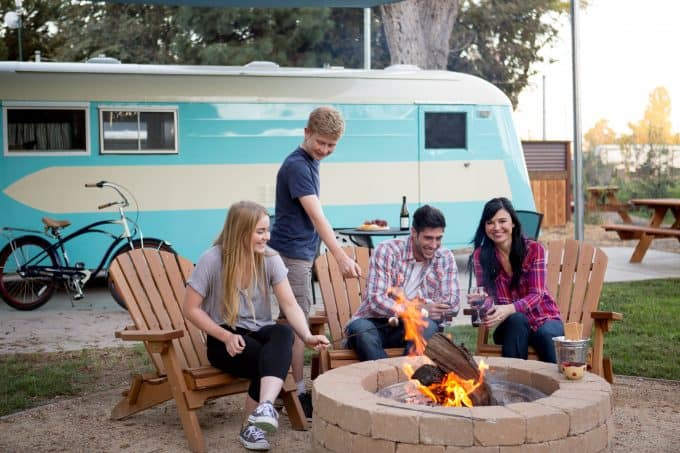 Family roasting marshmallows at fire pit in Flying Flags RV Resort in California