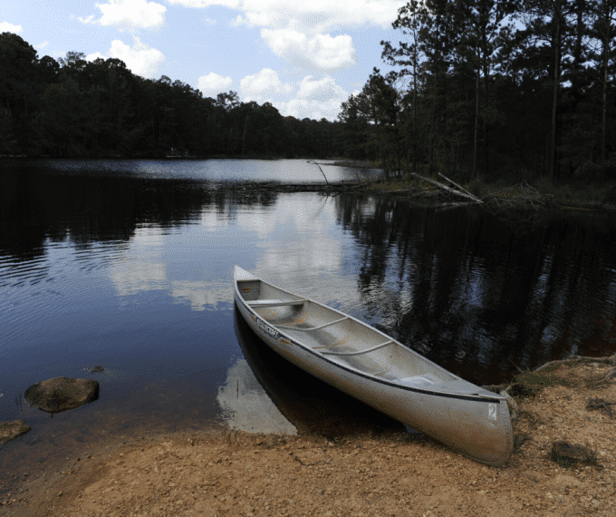 Canoe on shore of lake.