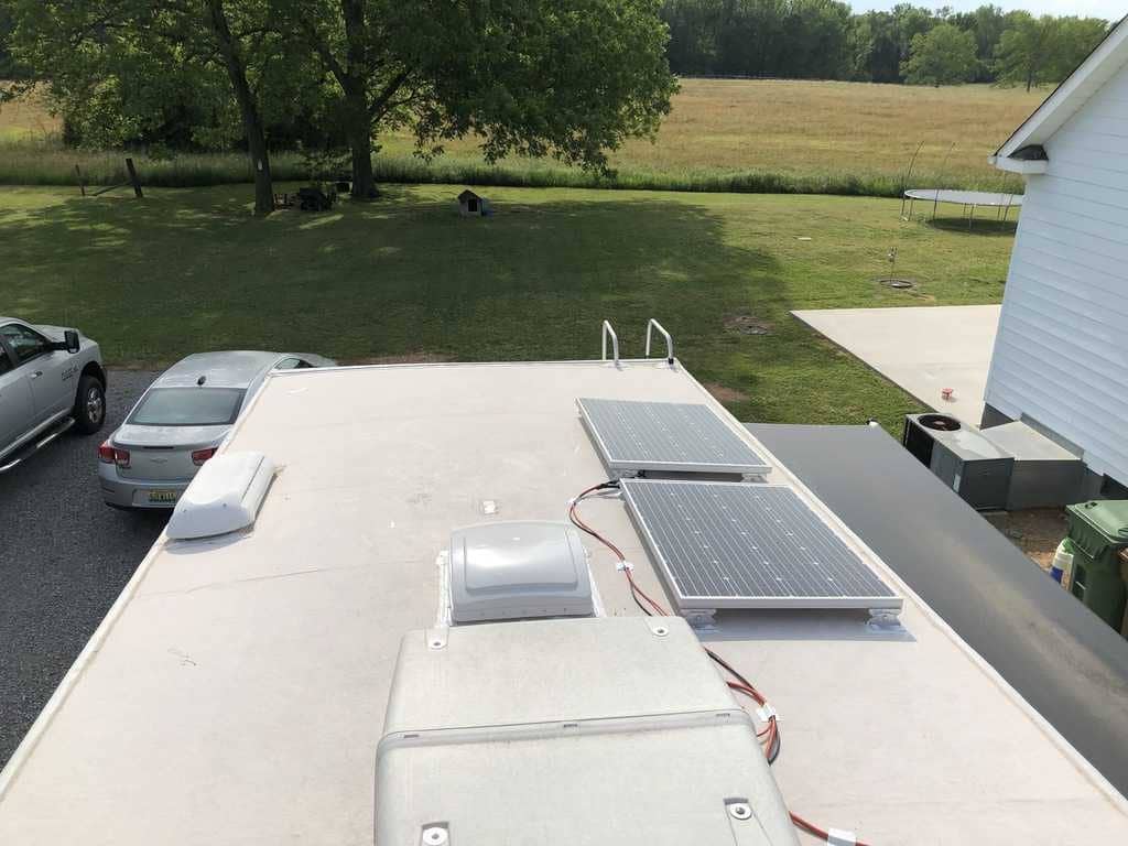 Solar panels on roof of RV parked in lot near building