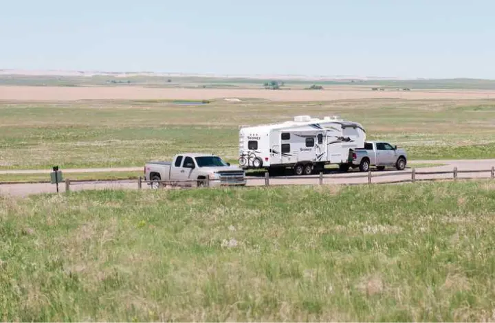Truck pulling fifth wheel trailer through Badlands National Park in South Dakota