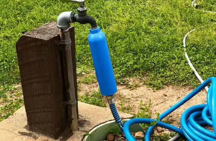 Blue filtration attached to water spigot and garden hose for RV drinking water