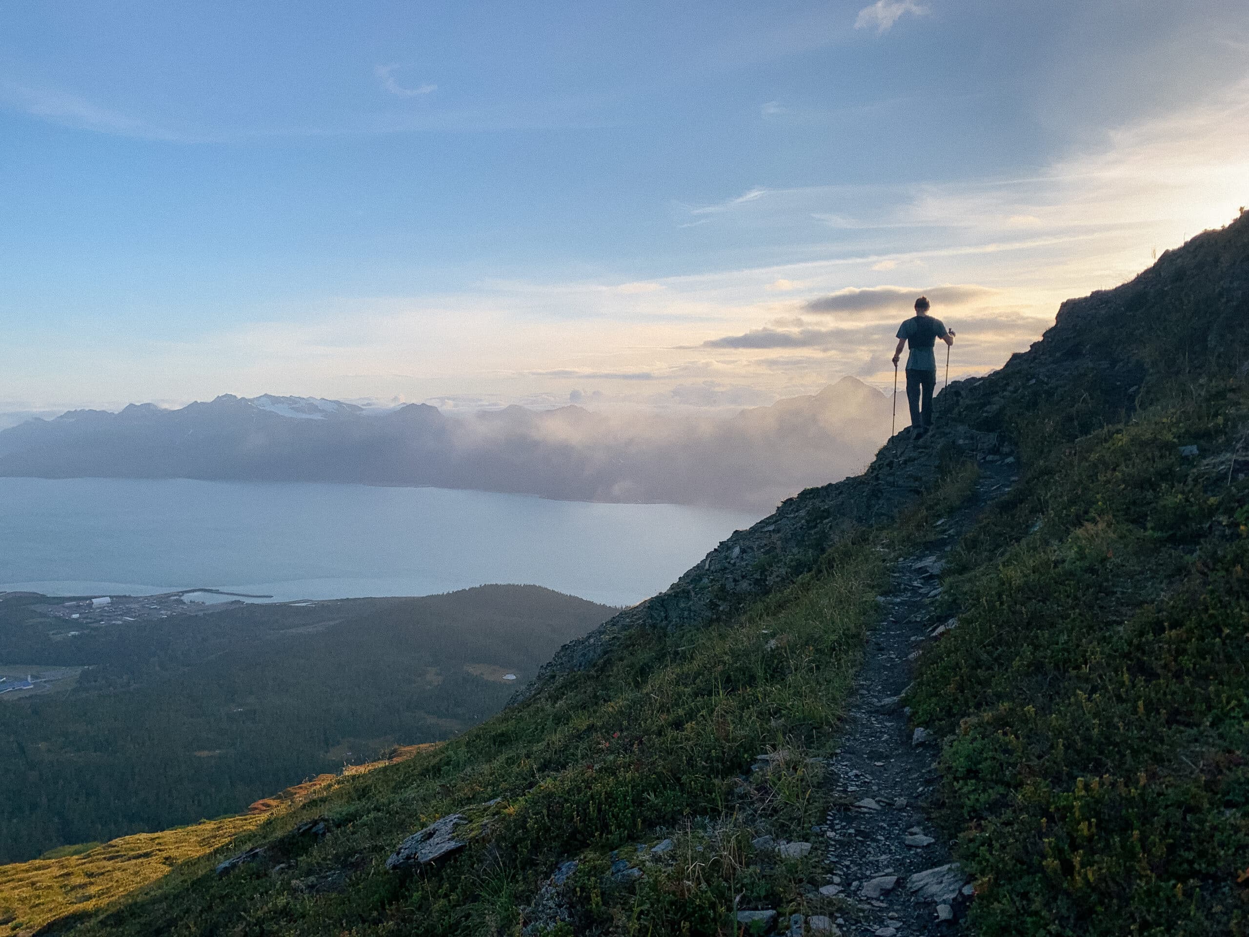 Man hiking on side of mountain overlooking lake