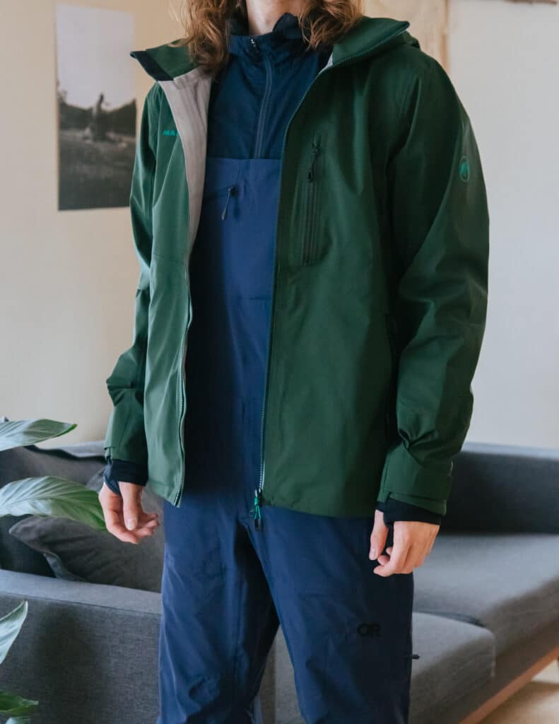 Man wearing waterproof winter bib overall pants and hardshell outer layer jacket