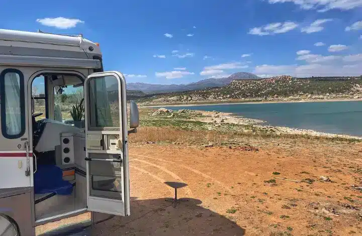 RV with door opened parked near lake