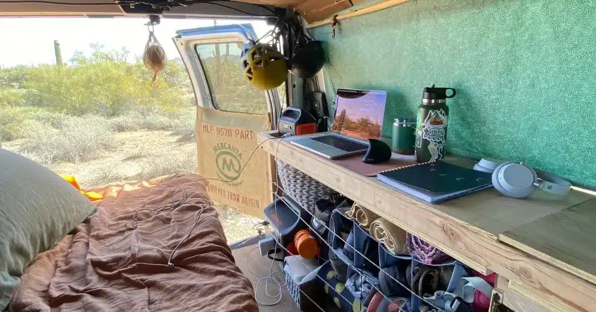 Shelves full of personal items with laptop and dog toys on top inside campervan