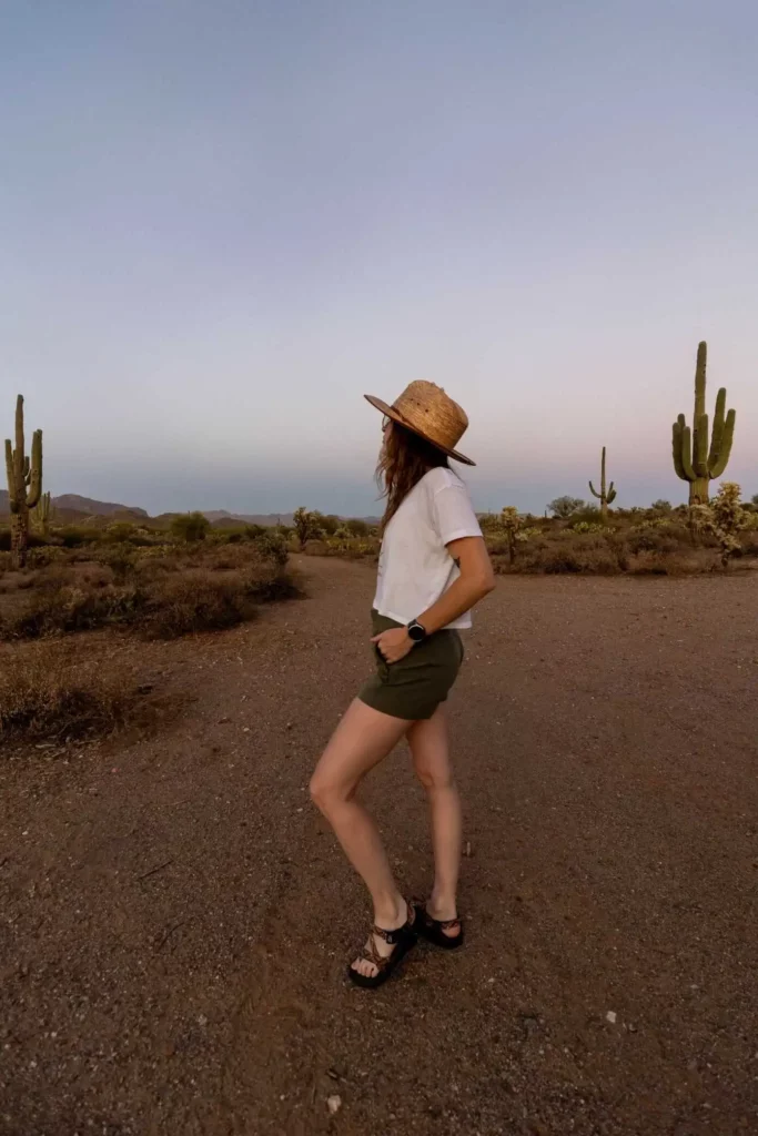 Side view of woman wearing hat and shorts standing outdoors