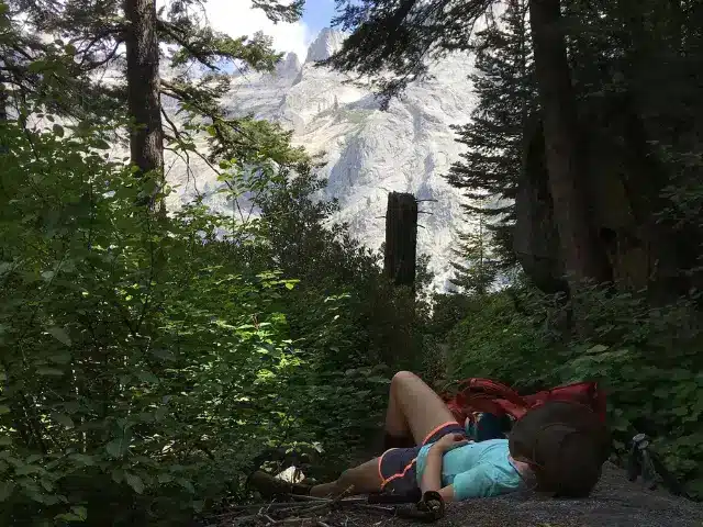 Solo hiker resting during a hike, one of the top backpacking tips for beginner is to enjoy a packs-off break