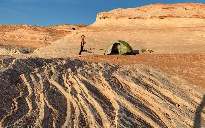 Woman with two near tent pitched in Badlands National Park.