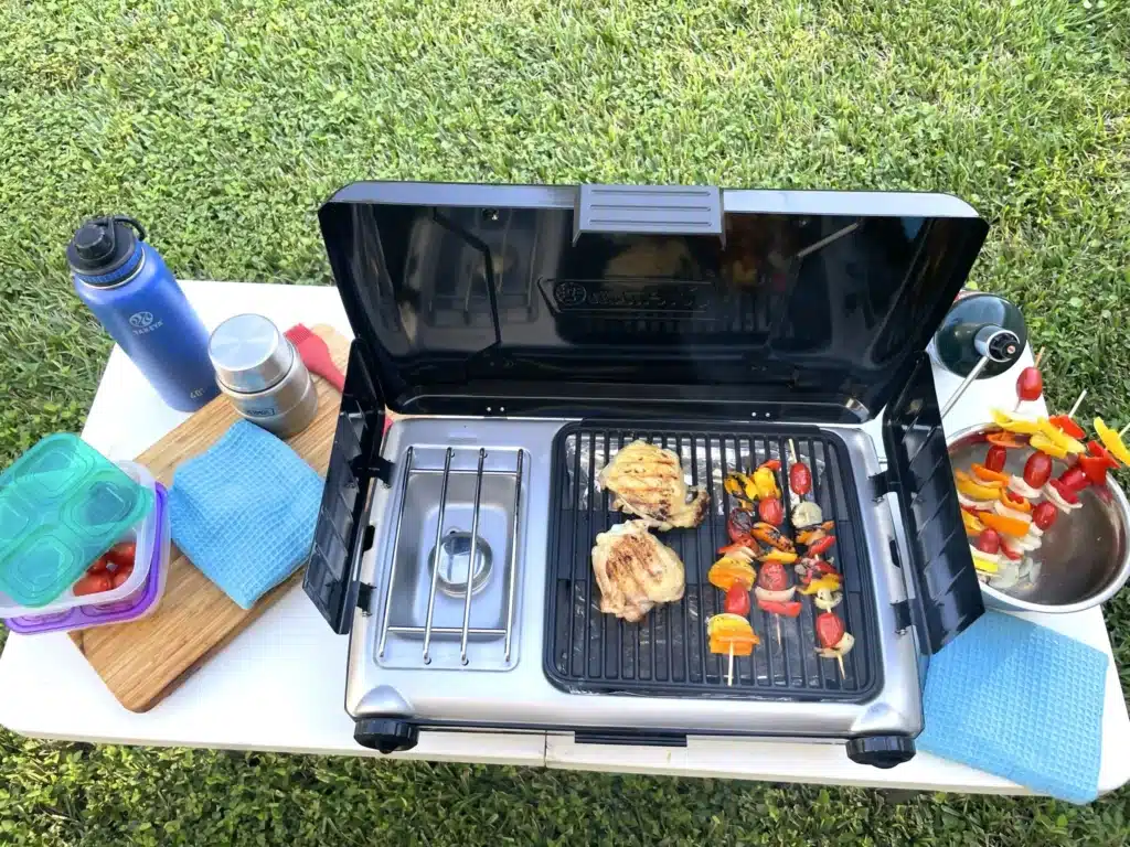 Camping grill and cooking accessories set on portable white table