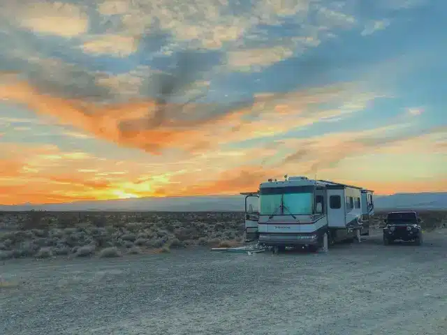 Class A RV parked in boondocking with vivid sunset in background