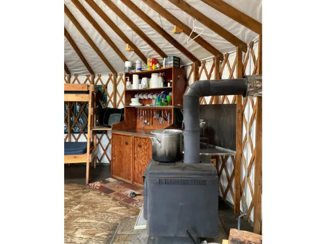 Wood stove and cabinet inside a yurt.