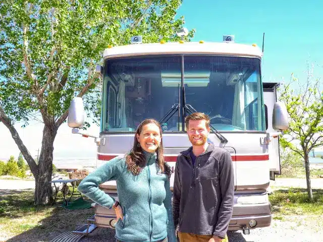 Woman and man standing in front of their Class A RV.