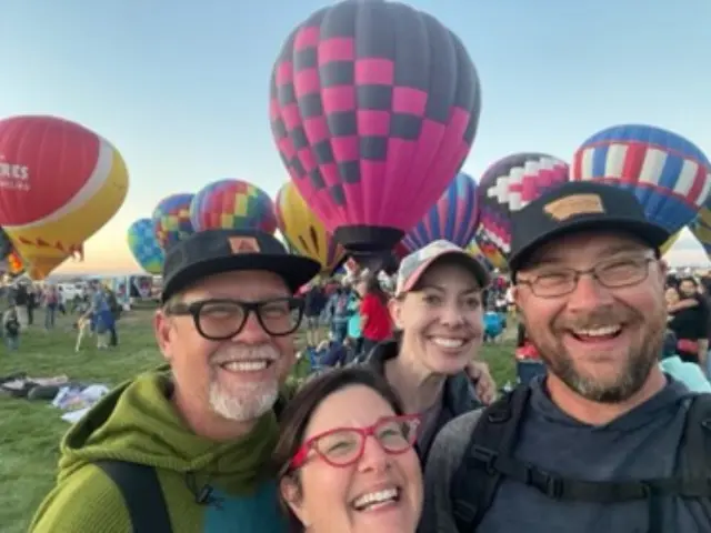 Group of four friends at a hot air balloon festival