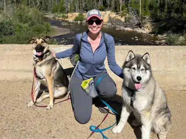 Woman outdoors with her two dogs.