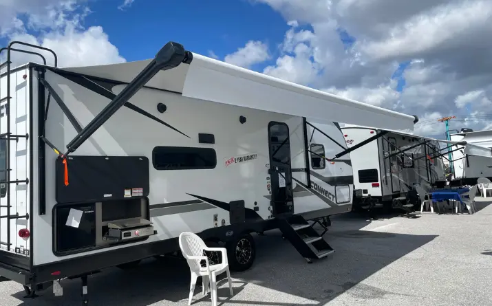 White travel trailer with an outdoor kitchen seen at RV show in Florida
